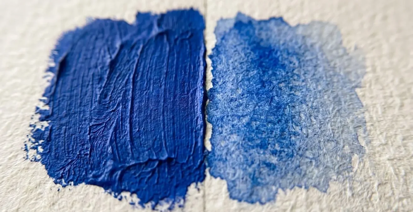 Close-up macro shot of paint textures showing acrylic opacity versus watercolor transparency on paper